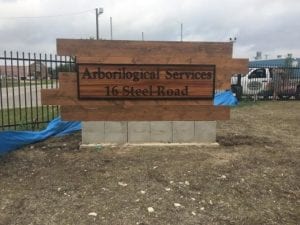 Wooden storefront sign for Arborilogical Services