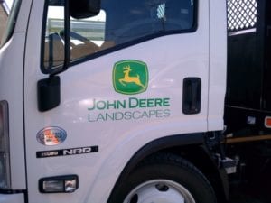 Close up of 18-wheeler cabin door with John Deer Landscapes vinyl decals